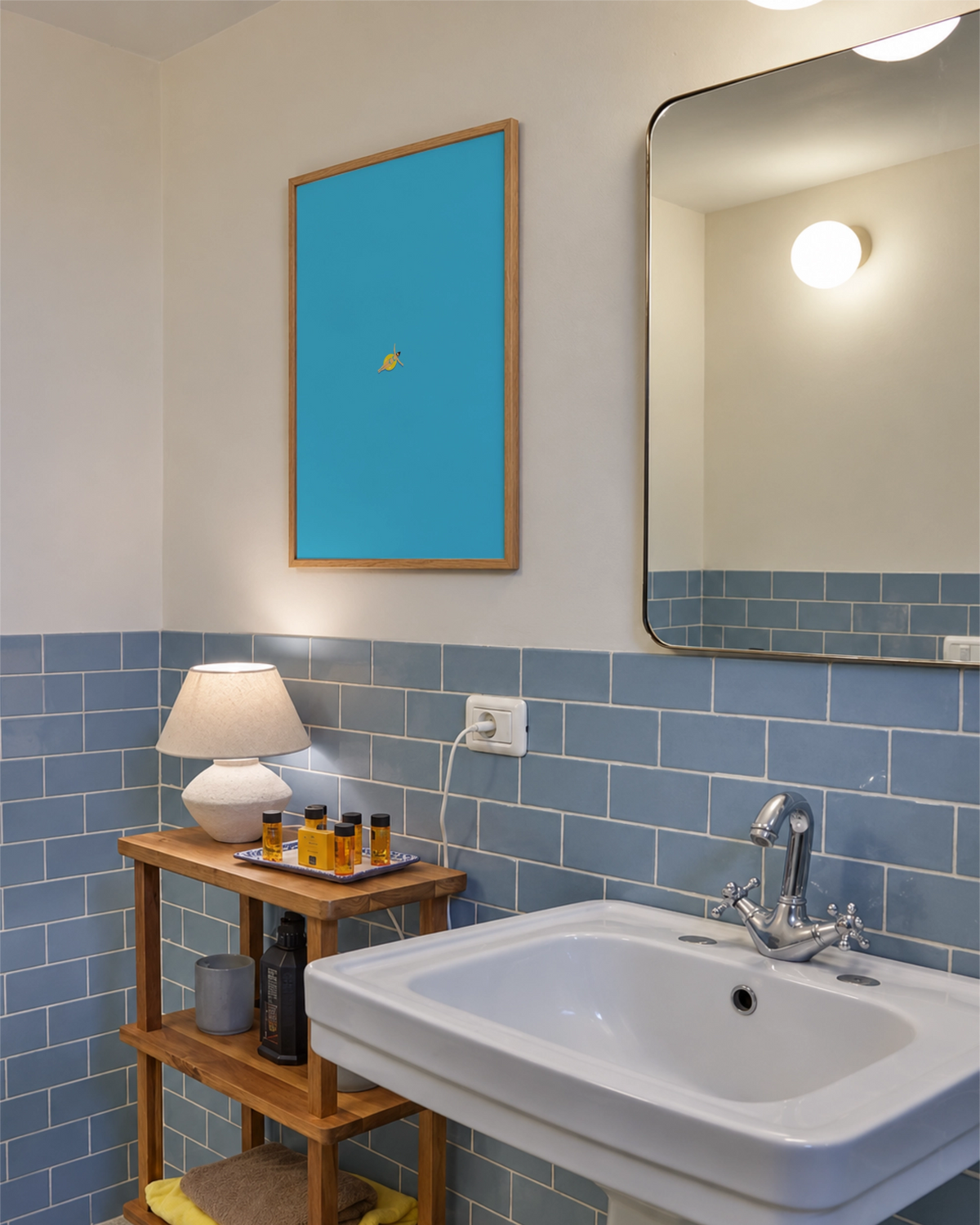 Lámina Out of Office enmarcada sobre un estante de madera en un baño de azulejos azul claro, con un bañista diminuto en un flotador amarillo.