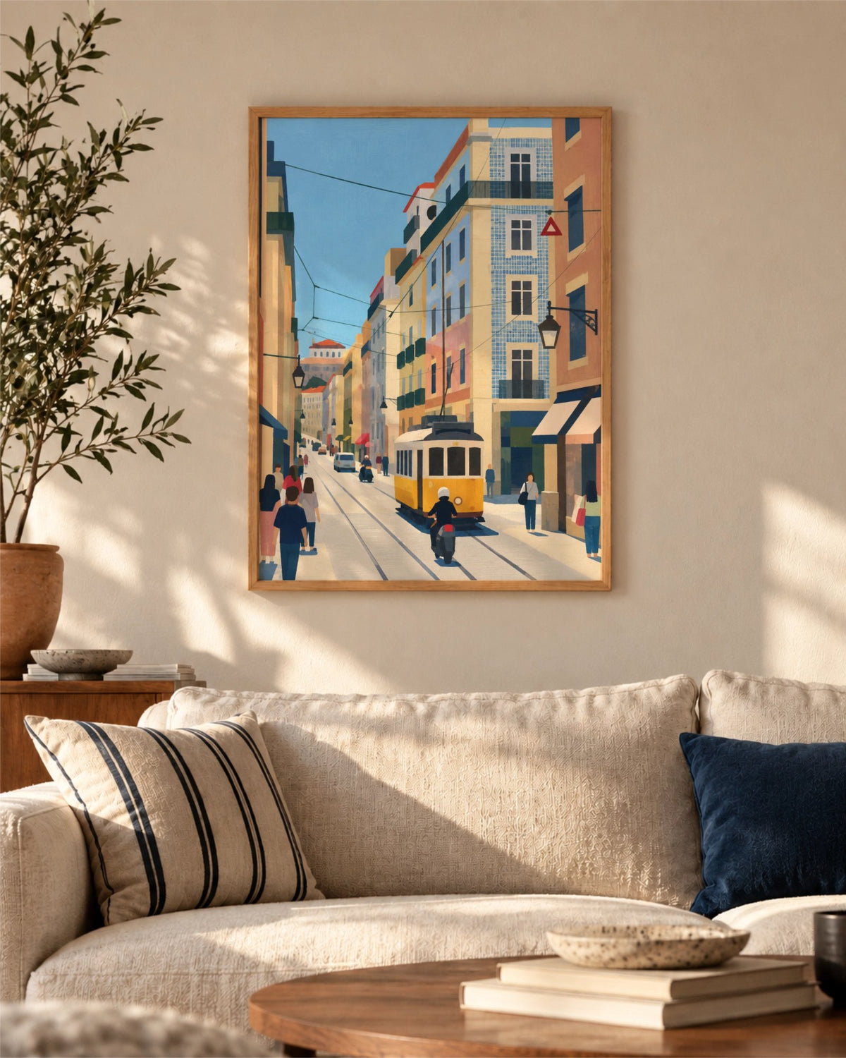 Lisbon in Motion art print in a natural wood frame above a cream sofa in a warm sunlit living room.