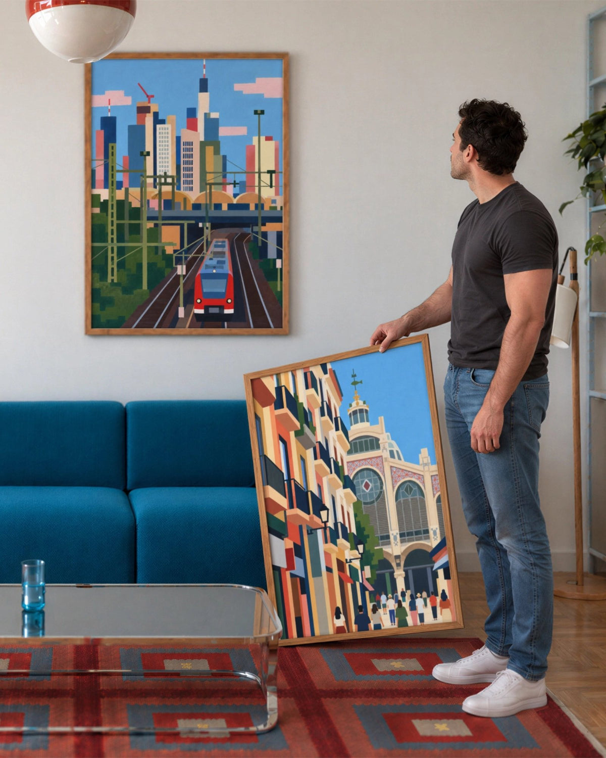 In Transit art print framed above a blue sofa while the matching Valencia in Color city print is held in the foreground.