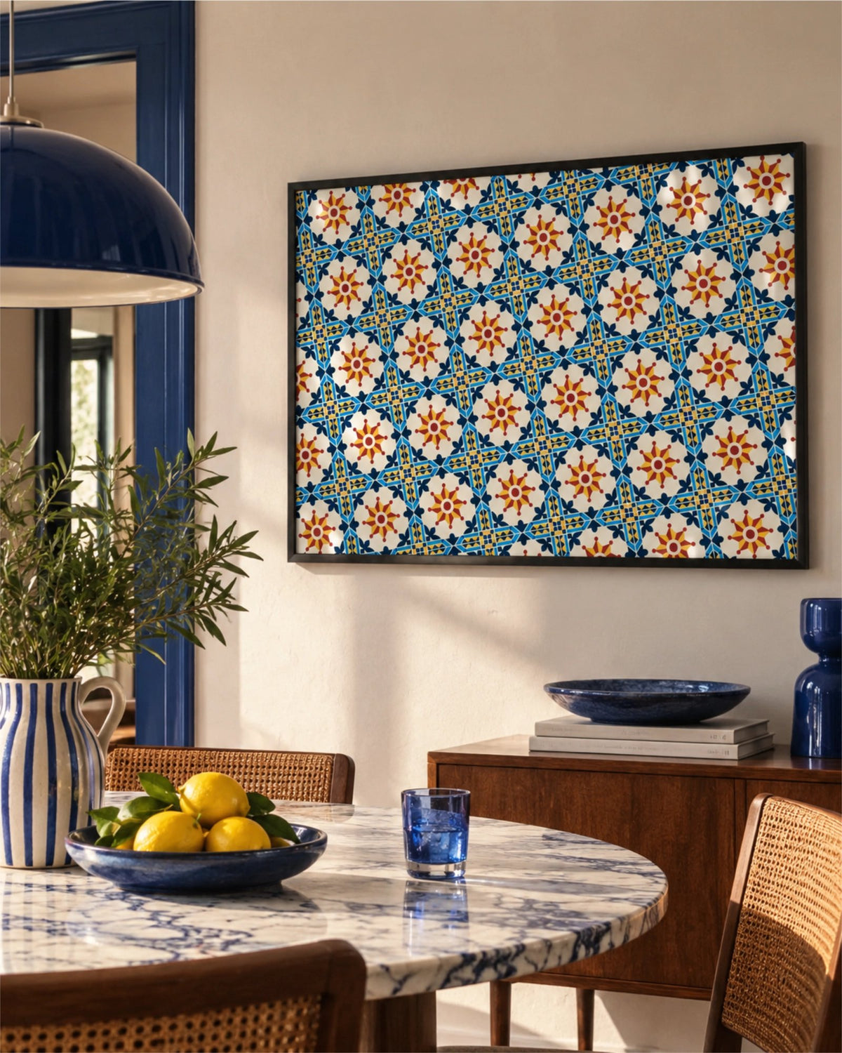 Affiche Porto Grid en cadre noir au-dessus d’un coin repas aux touches bleues avec table en marbre, chaises cannées et citrons frais