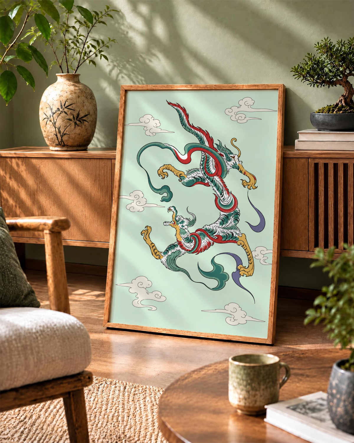 Lámina Dragon Dance en marco de madera natural apoyada en una pared verde, junto a un jarrón de cerámica, un bonsái y un mueble de madera.