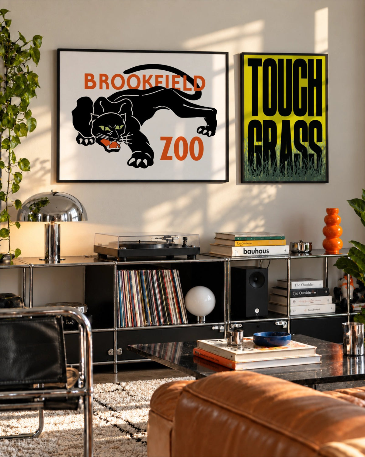 Lámina Night Prowl junto a Touch Grass sobre un mueble modular negro en un salón contemporáneo y luminoso