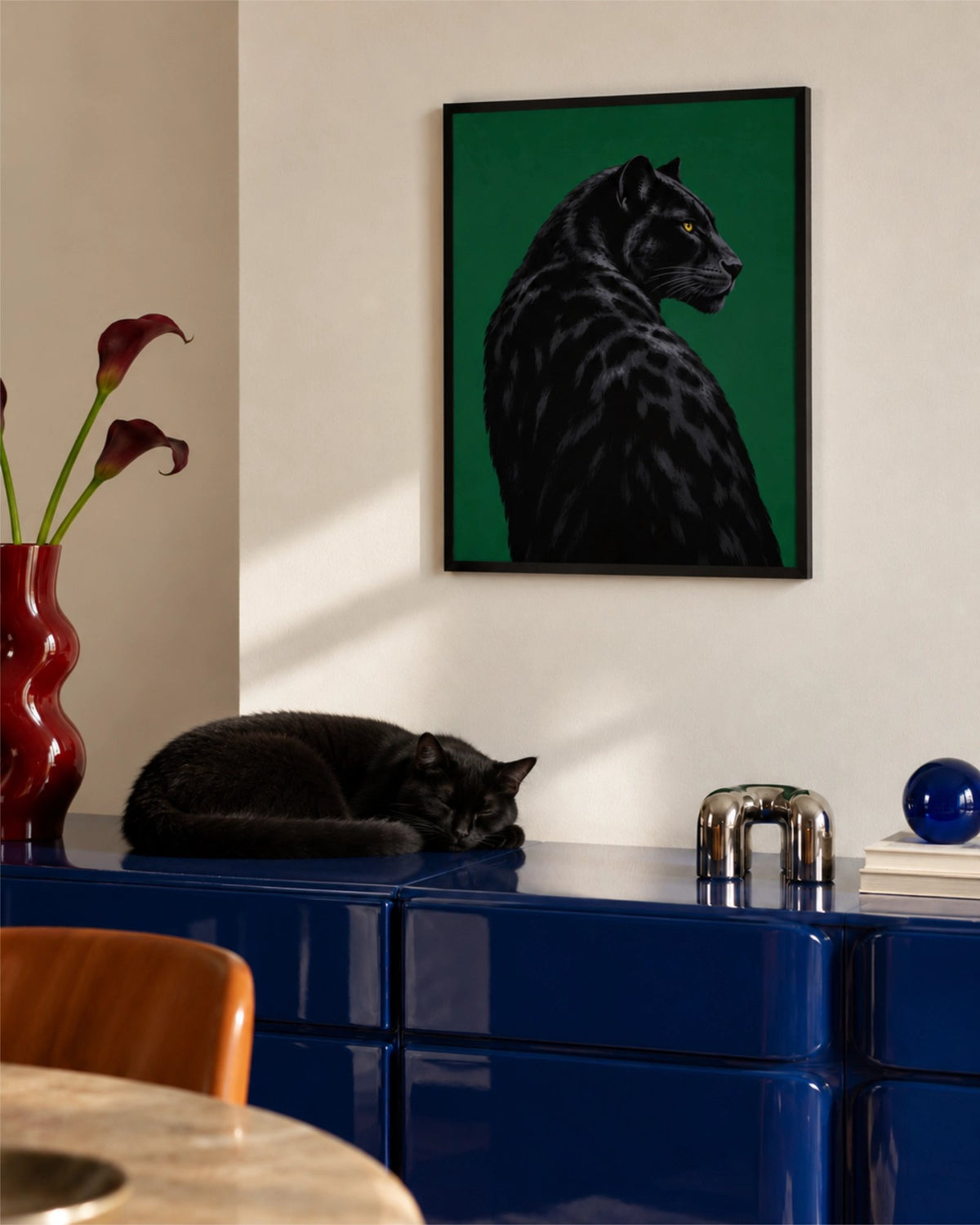 Lámina Black Panther sobre un mueble azul con un gato negro dormido debajo