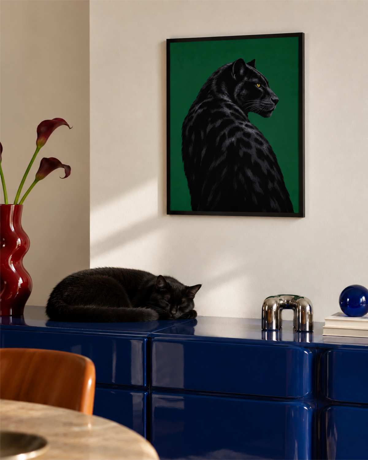 Black Panther poster above a blue cabinet with a black cat sleeping beneath it.