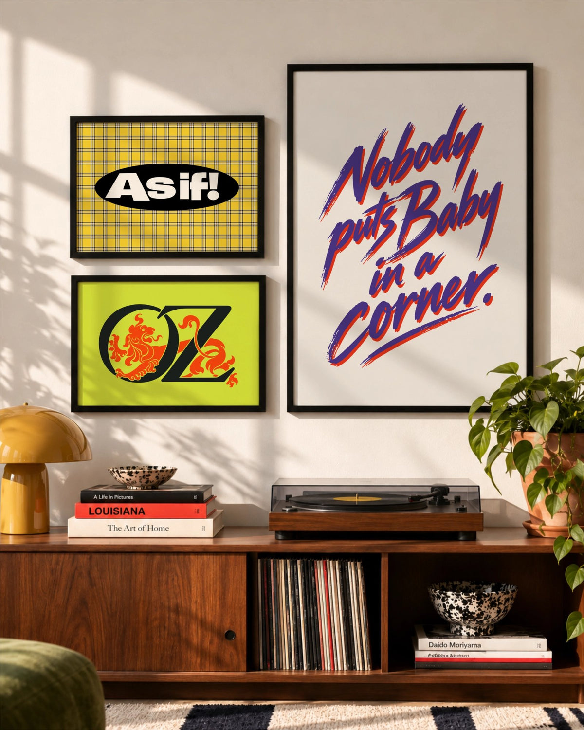 As If and Nobody Puts Baby in a Corner typographic art prints displayed together in a gallery wall above a walnut media console.
