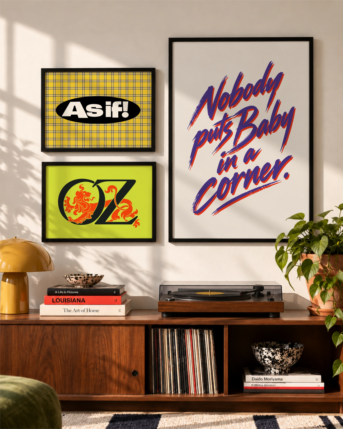 Typografische kunstdrukken As If en Nobody Puts Baby in a Corner samen in een fotowand boven een notenhouten tv-meubel.